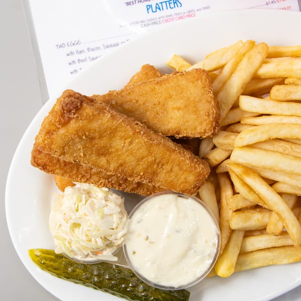 Seaport Diner's fish and chips platter with coleslaw, tartar sauce, and a pickle spear.