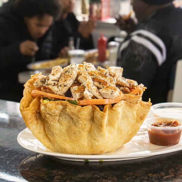 A large Seaport Diner chicken taco salad in a crispy fried tortilla bowl with sauces.